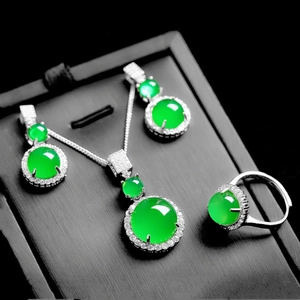 Detailed view of green chalcedony jewelry set with necklace earrings and ring on stand