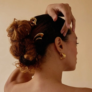 Model wearing gold 18k stainless steel U-shaped hairpins and matching hoop earrings