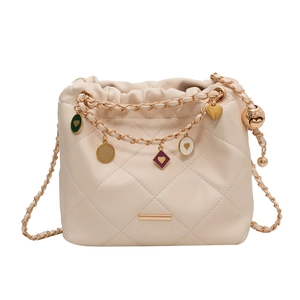 Sac seau matelassé blanc crème avec bandoulière chaîne dorée et breloques de cœur