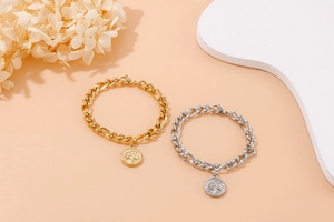 Detail of gold and silver tree of life coin pendants on thick link chain bracelets