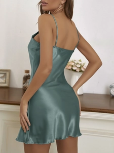 Detail of silk satin camisole dress in sage green showing fabric texture and drape