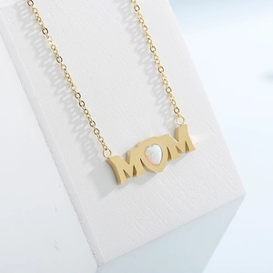 Gold MOM letter necklace with heart-shaped white opal stone on a white background