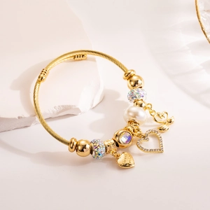 Gold adjustable charm bracelet with pearls, crystal beads, and heart swan pendants