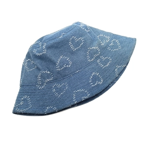 Detailaufnahme eines blauen Denim-Anglerhuts mit weißem Herzmuster und Stickereien