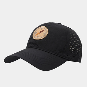 Detail of black quick-dry baseball cap with laser-cut side vents and compass patch