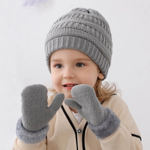 Detail of light gray knit baby hat and gloves with warm plush lining and thick texture