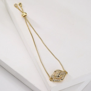 Macro detail of gold-plated leopard head charm with cubic zirconia on adjustable bracelet