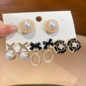 Detail view of 5-piece earring set featuring pearls and black camellia designs
