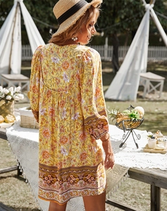 Détail de robe d'été bohème montrant l'imprimé floral vif et le tissu fluide au dos