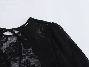 Détail de la texture en dentelle noire et du nœud papillon au dos de la robe