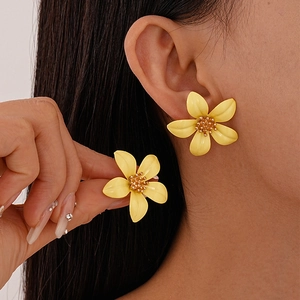 Elegant yellow floral earrings with five petals and gold core worn by model in a close-up shot