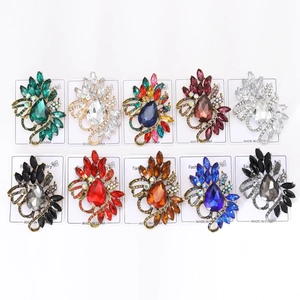 Macro shot of 10 vintage teardrop crystal brooches in various colors on display cards