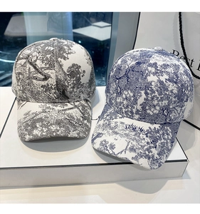 Detailed view of baseball caps with blue and black Toile de Jouy vintage floral patterns