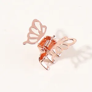Detail of rose gold butterfly hair claw clip with delicate hollowed-out metal wings