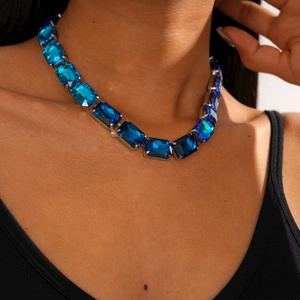 Close-up of luxury geometric necklace featuring large blue rectangular gemstones and silver finish