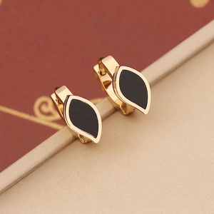 Close-up of gold-plated stainless steel huggie earrings with black enamel leaf detail