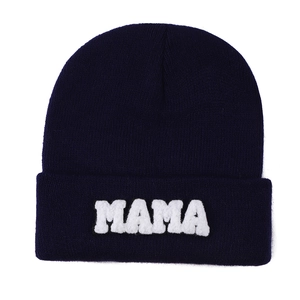 Detail of navy blue beanie featuring white MAMA towel embroidery on the fold cuff