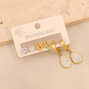 Detailed macro view of 3 pairs of gold stainless steel heart and geometric stud earrings