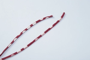 Detailed view of dark red polka dot fabric straps with white print and fine stitching