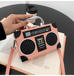 Detailed view of pink vintage radio-shaped crossbody bag with FM scale and silver handle