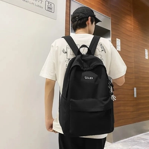 Close-up of black backpack with creative astronaut pendant on durable nylon material