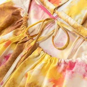Dettaglio dell'abito tie-dye con lacci allacciati al collo e increspature elastiche