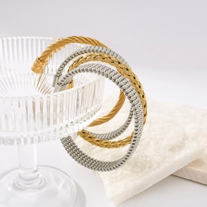 Twisted wire cable bangles in gold and silver finish on striped glass for women