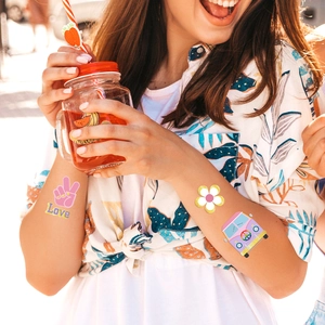 Hippie temporäre Tattoos mit Goldfolie Peace and Love Motiven auf dem Frauenarm