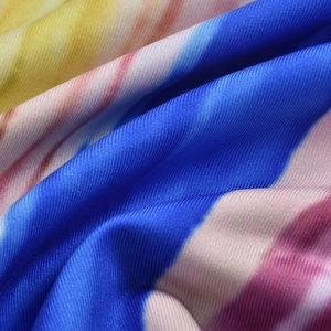 Dettaglio del tessuto a maglia sfumato blu giallo e rosa con trama intrecciata