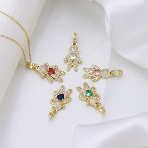 Gold plated girl and boy necklaces with colorful heart cubic zirconia on silk background