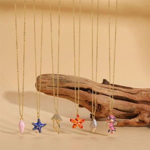 Marine ocean necklaces set with starfish shell pendants on gold chains and wood display