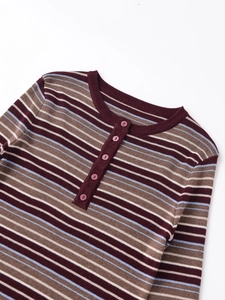 Close-up of multicolored striped knit top with Henley neckline and pink button details