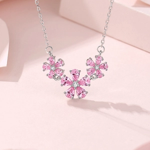 S925 sterling silver necklace with three pink zircon peach blossom pendants on a pink background