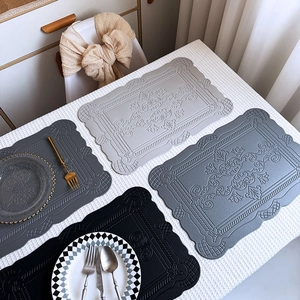 Nordic faux leather placemats with embossed vintage pattern and wavy edges in four shades of grey