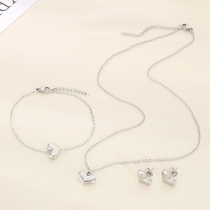 Three-piece silver heart jewelry set including a necklace, bracelet, and stud earrings