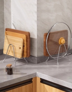 Detail showing stainless steel rack holding a wooden cutting board and glass lid