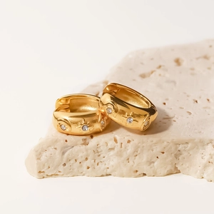 Close-up of 18k gold plated chunky hoops with star and moon zircon inlay on stone