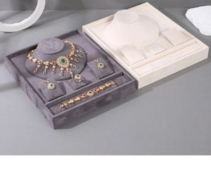 Detail of grey velvet jewelry display tray set showing necklace and ring compartments