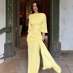 Detail view of the yellow long dress featuring elegant pleats and long waist ribbons