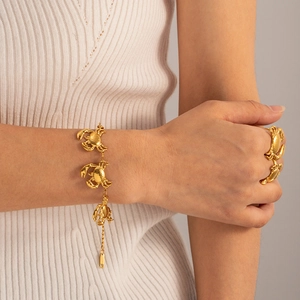 Golden titanium steel crab bracelet and ring set worn on a model with white knit top