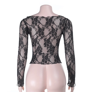 Macro detail of sheer black floral lace fabric on a fitted long sleeve crop top