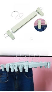 Detail of mint green pants hanger with a 360-degree rotating hook and heavy-duty spring clips