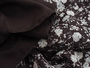 Detailed macro view of deep brown fabric featuring blue and white floral patterns