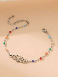 Detail of colorful beads and interlocking heart charm on a gold-plated Mobius link bracelet