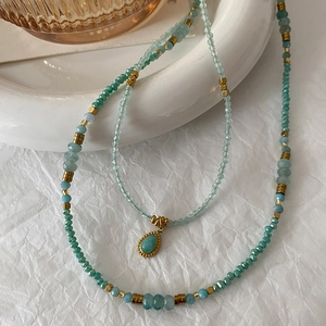 Double-layered amazonite bead necklace with gold accents and a teardrop stone pendant