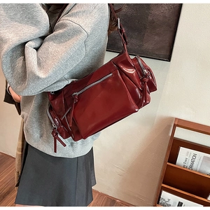 Mannequin portant un sac bandoulière rouge foncé en cuir délavé avec plusieurs zips