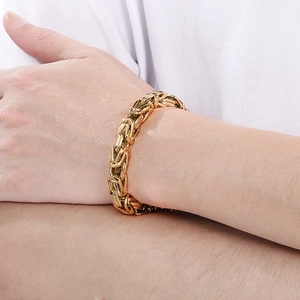 Close-up of polished gold punk style square curb chain bracelet for men on wrist