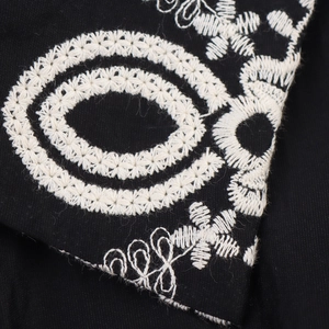Elegant black shirt dress featuring detailed white geometric embroidery on cotton fabric