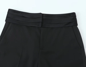 Vue détaillée du pantalon noir avec taille plissée et poches latérales pratiques