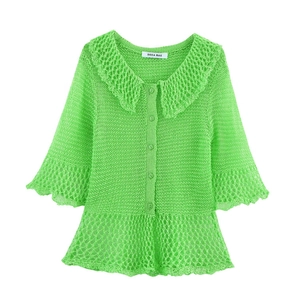 Detail of bright green hollow-out knit cardigan featuring a lapel collar and ruffle hem